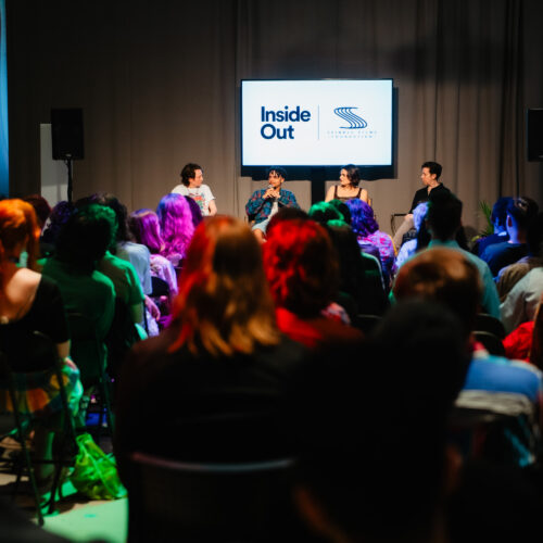 A crowd full of people looking at the stage of four panelists speaking. A screen in the back that reads Inside Out and Spindle Films Foundation.