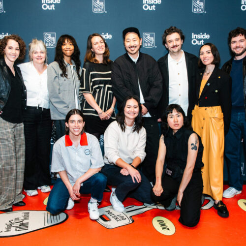 A group of eleven people pose together, smiling, in front of a blue backdrop with "Inside Out" and "RBC" logos. Some are standing, others are kneeling, dressed in casual and semi-formal attire.